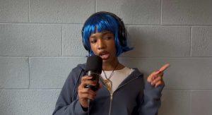 Dumebi, Nigerian singer, with Blue hair holding a mic