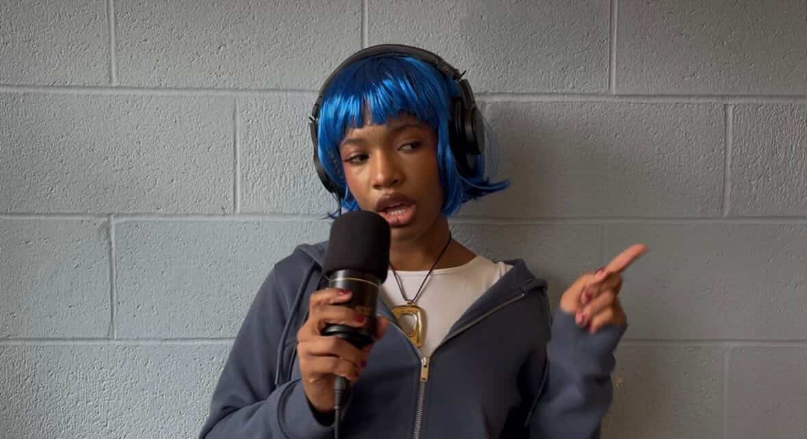 Dumebi, Nigerian singer, with Blue hair holding a mic